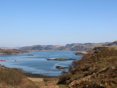 A coastal landscape with hills water and boats at WildLuing in Cullipool Isle Of Luing