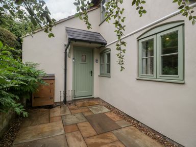 An outdoor area with a green door and windows at 2 Loxter Villas Wellington Heath near Ledbury