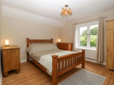 A bedroom with a bed and bedside tables at 2 Loxter Villas Wellington Heath near Ledbury