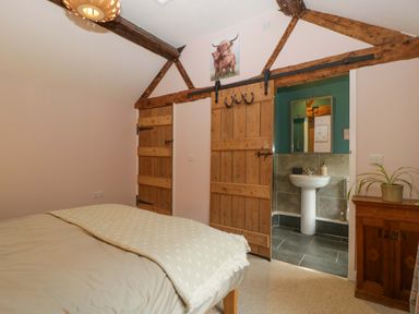 A bedroom with a bed and an attached bathroom at 2 Loxter Villas Wellington Heath near Ledbury