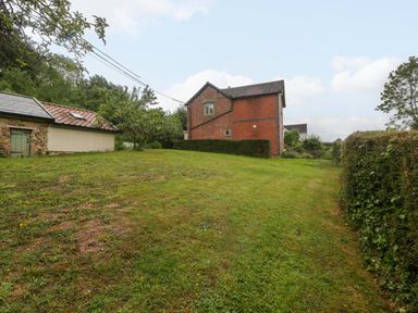A view of a house and shed in a grassy area at 2 Loxter Villas Wellington Heath near Ledbury