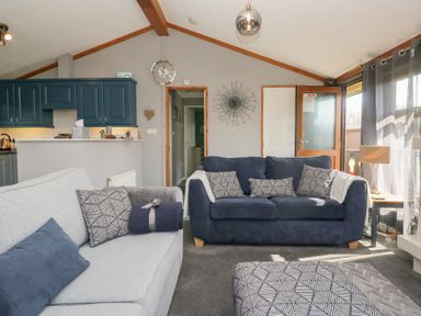 A living room with two sofas and a kitchenette at Sunset Retreat in South Lakeland Leisure Village near Carnforth
