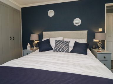 A bed with pillows and lamps on bedside tables in a bedroom at Sunset Retreat in South Lakeland Leisure Village near Carnforth