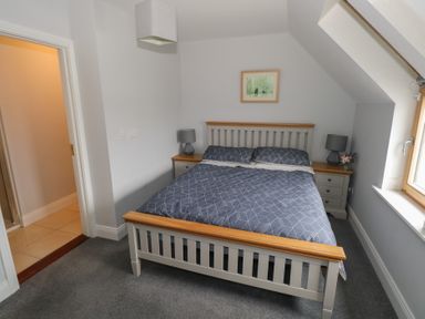 A bedroom with a double bed two bedside tables with lamps and a framed picture on the wall at C65 Cahermore Holiday Village Enniscrone County Sligo
