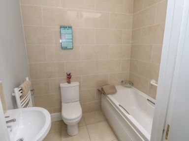 A bathroom with a toilet sink bathtub and towels at C65 Cahermore Holiday Village Enniscrone County Sligo