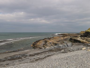 A rocky shoreline with waves and cloudy sky at C65 Cahermore Holiday Village in Enniscrone County Sligo