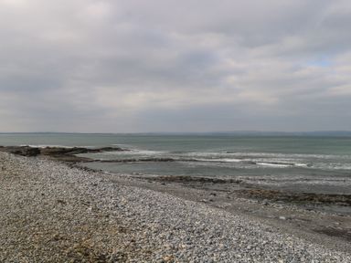 A rocky beach with waves and a cloudy sky at C65 Cahermore Holiday Village Enniscrone County Sligo