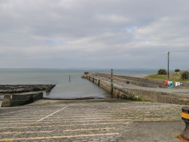 A boat ramp and pier extending into the sea under a cloudy sky at C65 Cahermore Holiday Village in Enniscrone County Sligo