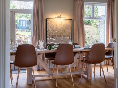 A dining room with a table set for meals at Marina View Bowness-On-Windermere