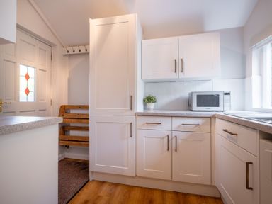 A kitchen with cabinets and a microwave at Marina View Bowness-On-Windermere