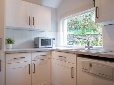 A kitchen with a microwave and a sink at Marina View in Bowness-On-Windermere