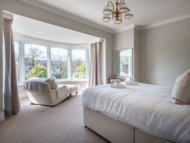 A bedroom with a bed and a chair at Marina View in Bowness-On-Windermere