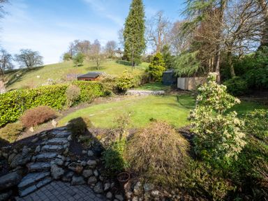 A garden with greenery and a shed at Marina View in Bowness-On-Windermere