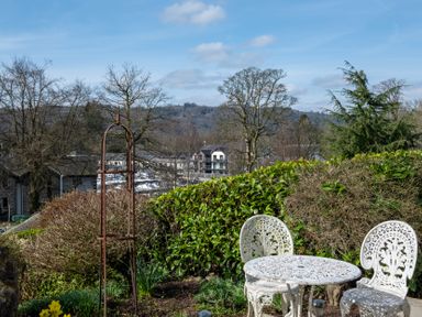 A garden with a table and chairs at Marina View in Bowness-On-Windermere