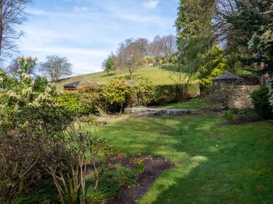 A garden with grass and shrubs at Marina View in Bowness-On-Windermere