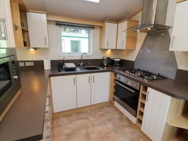 A kitchen with oven stove microwave sink and cabinets at Lodge 2 in Silverdale