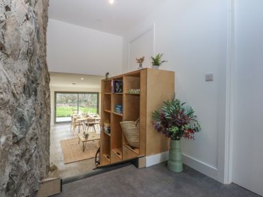 A dining room with a table and chairs at Tithe Barn Lodge Capel Mawr near Malltraeth