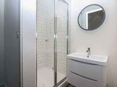 A bathroom with a shower and sink at Tithe Barn Lodge Capel Mawr near Malltraeth