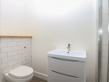 A bathroom with a sink, toilet, and shower at Tithe Barn Lodge Capel Mawr near Malltraeth