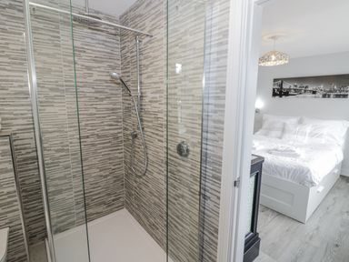 A bathroom with a shower and a bedroom at Chillon South Littleton near Honeybourne