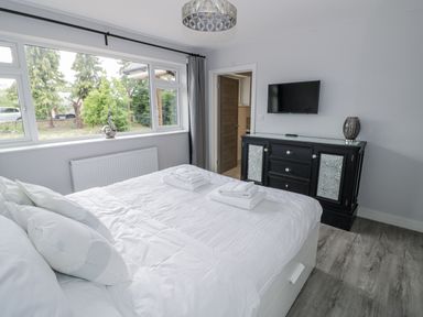 A bedroom with a bed and television at Chillon in South Littleton near Honeybourne