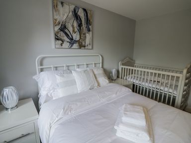 A bedroom with a bed and crib at Chillon South Littleton near Honeybourne