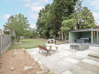 A garden with a patio area and a hot tub at Chillon South Littleton near Honeybourne