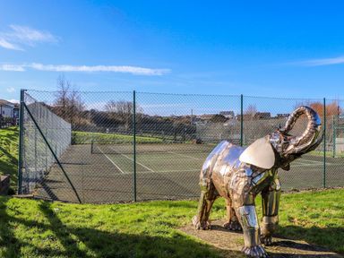 An elephant sculpture beside a tennis court at The Black Barnacle Portreath
