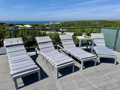 An outdoor area with lounge chairs and a table with champagne at The Black Barnacle in Portreath