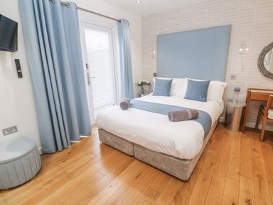 A bedroom with a bed and a window at The Black Barnacle in Portreath