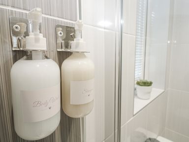 A body wash and shampoo mounted on a wall in a bathroom at The Black Barnacle in Portreath