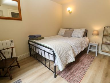 A bedroom with a bed with pillows and folded towels beside a lamp on a small table at Cottage Annex in Constantine
