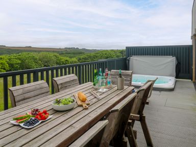An outdoor dining area with a table and chairs at Dahlia in Portreath
