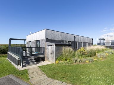 A building with a deck and garden at Dahlia in Portreath