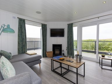 A living room with a sofa and television at Dahlia in Portreath