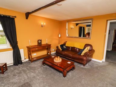 A living room with a sofa and coffee table at Petty Knowes Cottage near Rochester