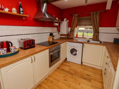 A kitchen with appliances and wooden countertops at Petty Knowes Cottage Rochester near Otterburn