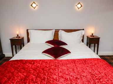 A bedroom with a bed and bedside tables at Petty Knowes Cottage Rochester near Otterburn