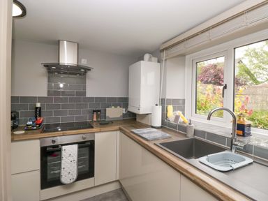 A kitchen with cabinets and an oven at Yeat Stoup Cottage in Cockermouth
