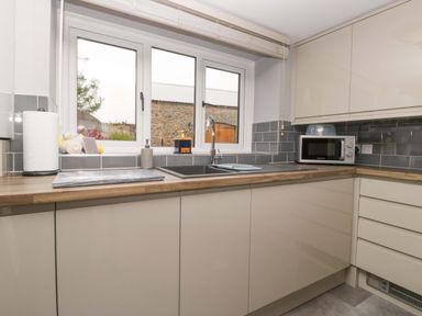 A kitchen with a sink and cabinets at Yeat Stoup Cottage in Cockermouth