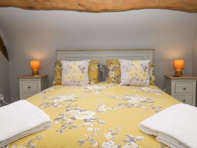 A bedroom with a double bed and bedside tables at Yeat Stoup Cottage in Cockermouth