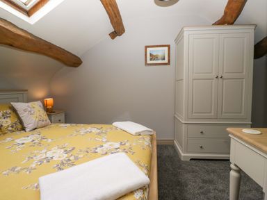 A bedroom with a double bed and wardrobe at Yeat Stoup Cottage Cockermouth
