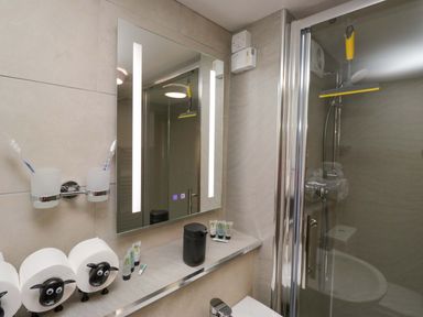 A bathroom with a shower and mirror at Yeat Stoup Cottage in Cockermouth