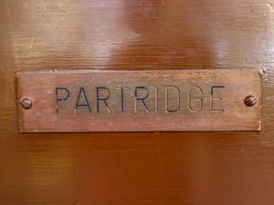 A close up of a plaque with the word Partridge on a wooden surface at Partridge in Withern near Alford