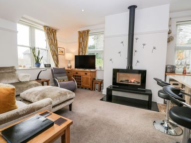 A living room with a fireplace television armchair and sofa at The Bolt Hole in Kendal
