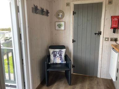 An entryway with a chair and hooks at Little Acre in Oxenhope