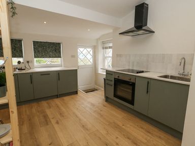 A kitchen with oven and sink at Sea Pink Studio in Swanage