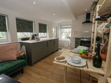A kitchen with dining table and fruit at Sea Pink Studio in Swanage