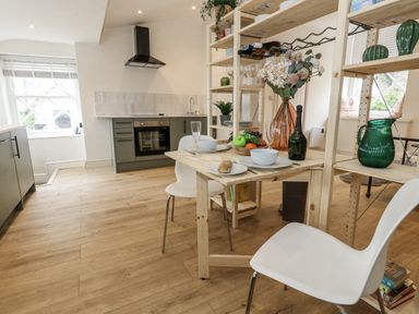 A kitchen with a table and chairs at Sea Pink Studio in Swanage