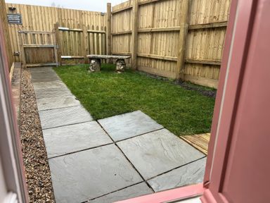A garden with slate paving and a bench at Sea Pink Studio in Langton Matravers